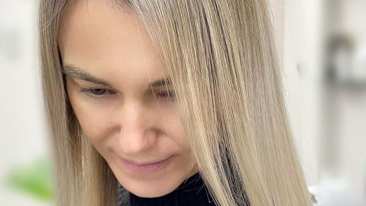 Lang blond haar, het hoofd licht gebogen