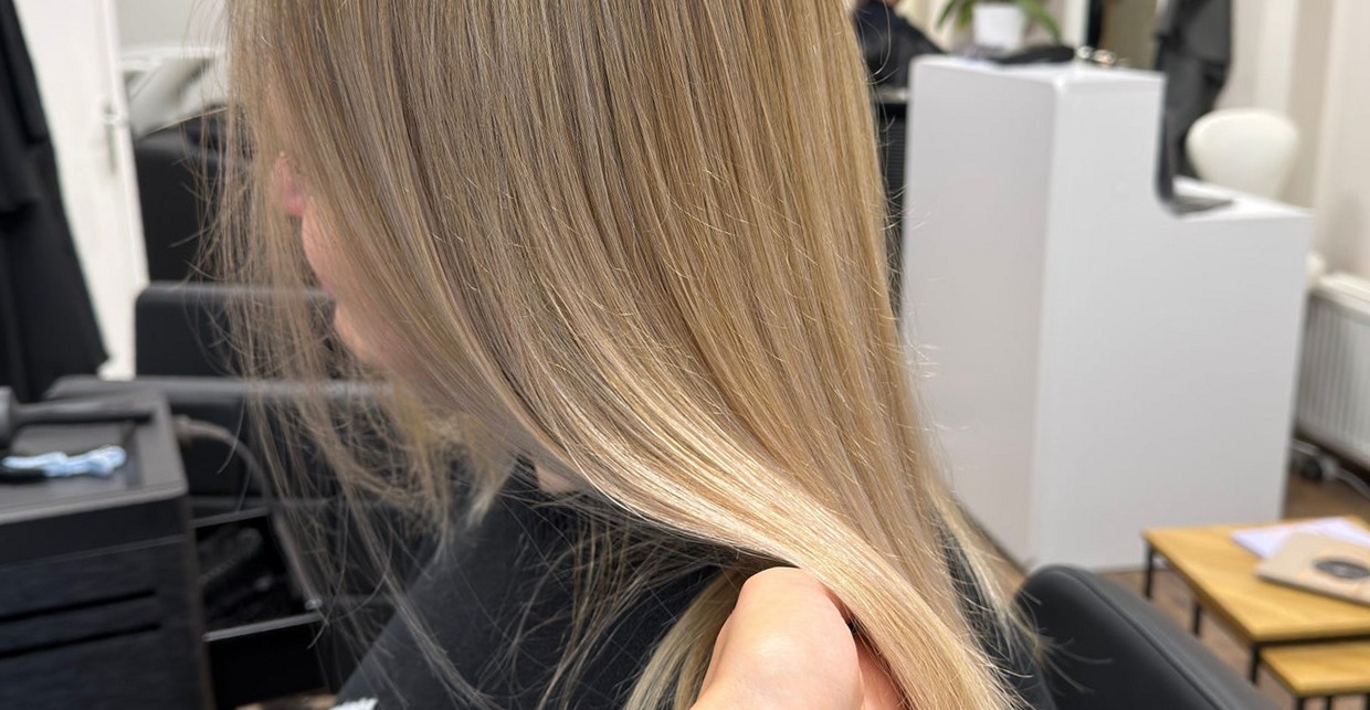 Lang lichtblond haar in de stoel, van opzij gezien